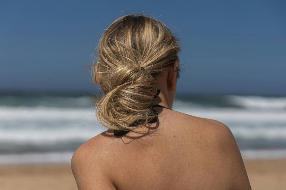 Woman showcasing a soft twisted low bun hair updo